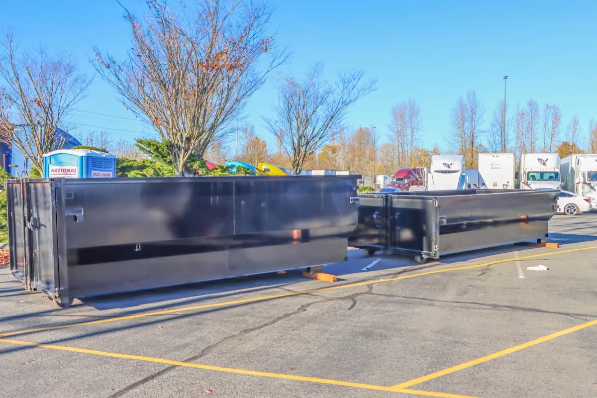 Professional dumpster rental service with roll-off container on residential driveway in East Providence